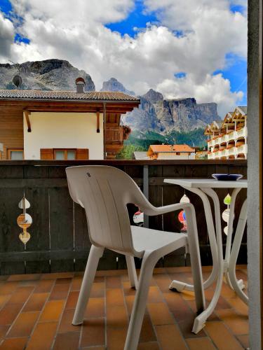 two chairs and a table on a balcony with a view at Garni Gabrieli in Corvara in Badia