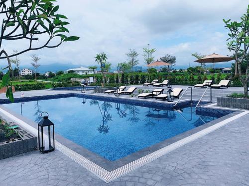 una gran piscina con sillas y sombrillas en Tsang Kuo Resort en Wujie