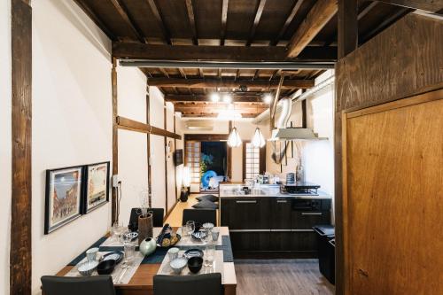 a kitchen and dining room with a long table and chairs at Prestige Suites Osaka Teradacho in Osaka