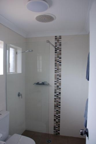a bathroom with a glass shower with a toilet at Highway Inn Motel in Hay