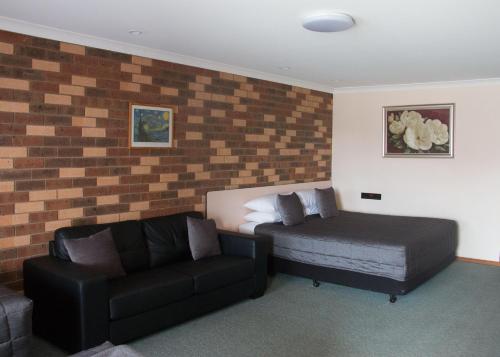 a living room with a bed and a couch at Highway Inn Motel in Hay