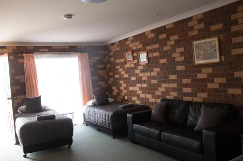a living room with a couch and a chair at Highway Inn Motel in Hay