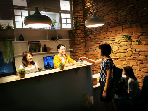 a group of people sitting at a counter in a restaurant at Bluewater Hotel Xpark Gloria Outlets Taoyuan Baseball Stadium in Dayuan