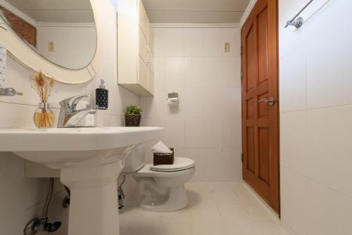 a bathroom with a sink and a toilet and a mirror at The Hyu Largo in Yongin