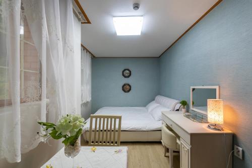 a bedroom with a bed and a desk with a mirror at The Hyu Largo in Yongin