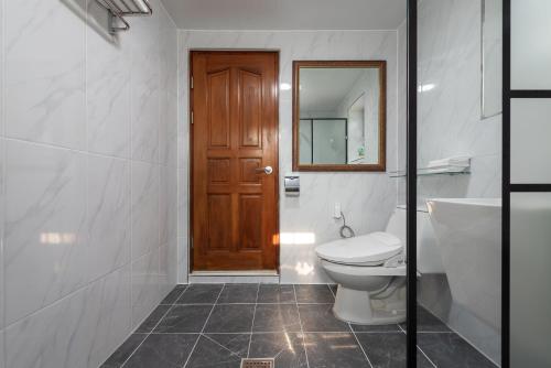 a bathroom with a toilet and a sink and a mirror at The Hyu Largo in Yongin