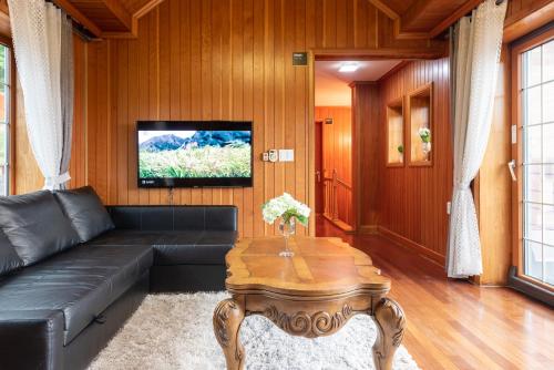 a living room with a black couch and a table at The Hyu Largo in Yongin