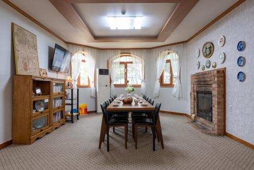 a dining room with a table and a fireplace at The Hyu Largo in Yongin