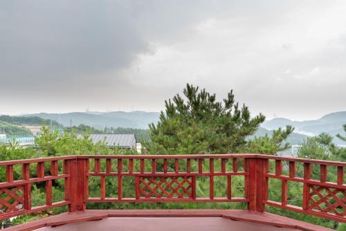 a wooden fence with a view of a mountain at The Hyu Largo in Yongin