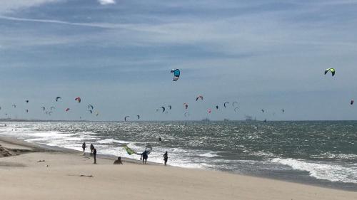 a group of people flying kites on the beach at Pousada & Food 3 Abelhas in Cumbuco