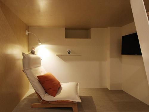 a living room with a white chair and a lamp at Tong Tong Petit Hotel in Seoul