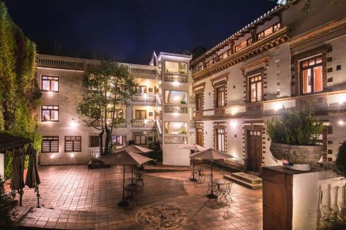 a large building with tables and umbrellas in a courtyard at Vista del Angel Hotel Boutique in Quito