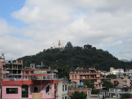 a hill with a temple on top of a city at STUPA VIEW INN in Kathmandu