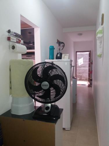 a black fan sitting on a counter in a kitchen at Apartamento 05 Vivendas do Serrano - Lençóis in Lençóis