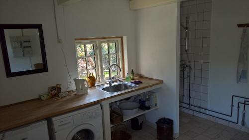 a kitchen with a sink and a washing machine at Thurup Hus in Assens