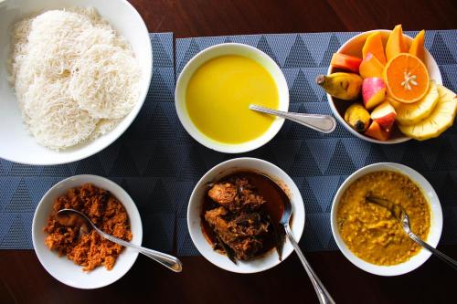 a table with bowls of food and a bowl of soup at Nimal's Home in Anuradhapura