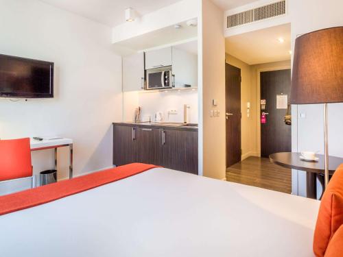 a hotel room with a bed and a kitchen at Adagio Nice Centre in Nice