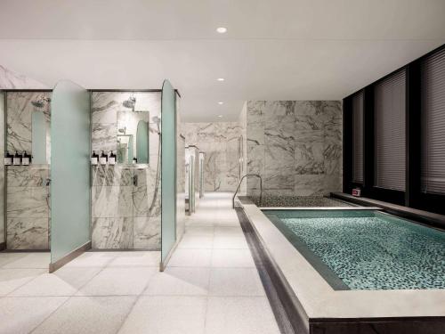 a bathroom with a swimming pool and marble walls at Novotel Suites Ambassador Seoul Yongsan in Seoul