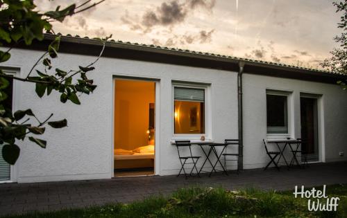 Casa blanca con cama en la ventana en Hotel Wulff, en Warburg