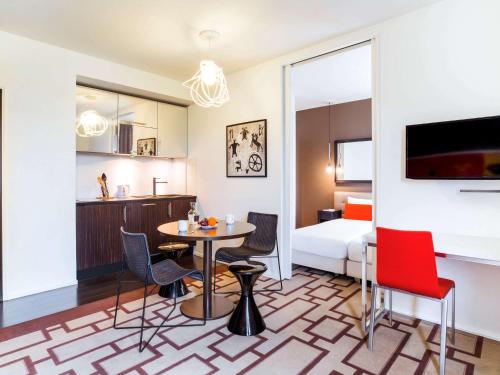 a room with a table and chairs and a bedroom at Adagio Grenoble Centre in Grenoble
