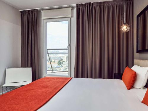 a bedroom with a large bed and a large window at Adagio Nice Centre in Nice