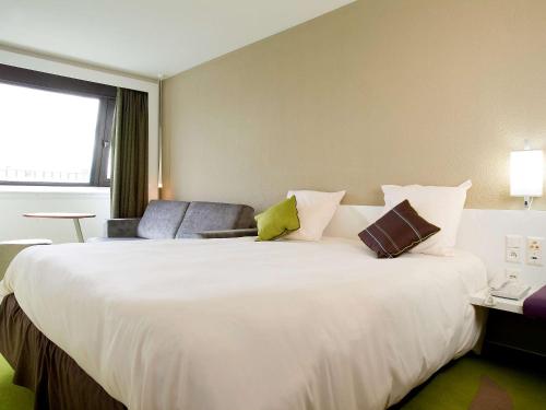 a large white bed in a hotel room at ibis Styles Bordeaux Aéroport in Mérignac