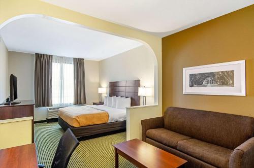 um quarto de hotel com uma cama e um sofá em Quality Inn & Suites Near Tanger Outlet Mall em Gonzales