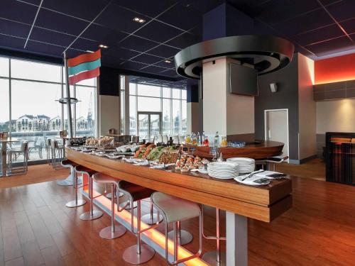 a long table with food on it in a restaurant at Novotel London Excel in London