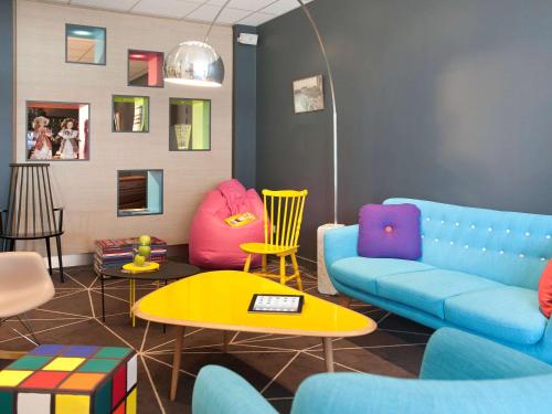a living room with a couch and chairs and a table at ibis Styles Roanne Centre Gare in Roanne