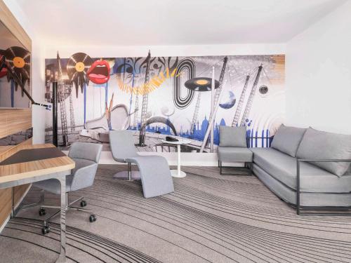 a living room with a couch and a mural at Novotel London Excel in London