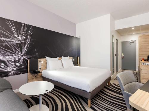 A bed or beds in a room at Novotel Tours Centre Gare