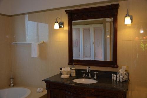 a bathroom with a sink and a mirror and a tub at Bli Bli House Riverside Retreat in Twin Waters