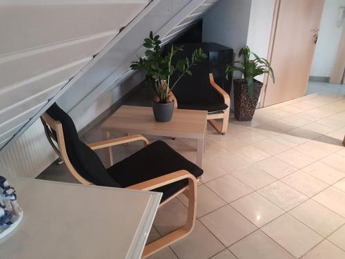 a staircase with two chairs and a table with plants at Gino s Ferienwohnung in Illingen