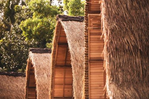 two straw umbrellas on the side of a building at Majango Bungalows in Kuta Lombok