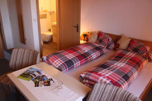 um quarto com duas camas e uma mesa e cadeiras em Haus Friedeck em Ramsau am Dachstein