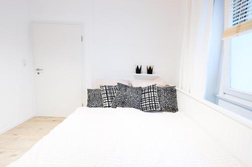 a white room with a bed with pillows on it at Köhlz Fewo im EG in Bornheim