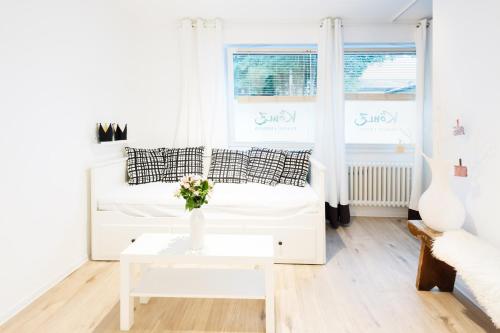 a white living room with a couch and a table at Köhlz Fewo im EG in Bornheim