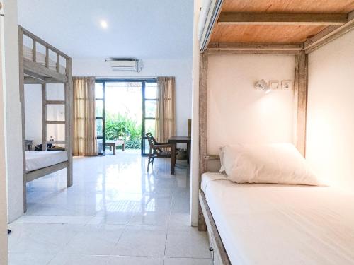 a bedroom with two beds and a dining room at Mangga Wangga Living in Uluwatu
