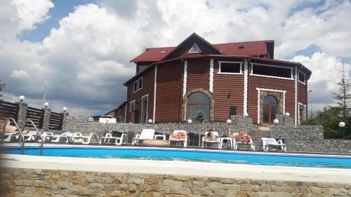 a house with a swimming pool in front of a house at Panorama Karpat in Yablunytsya