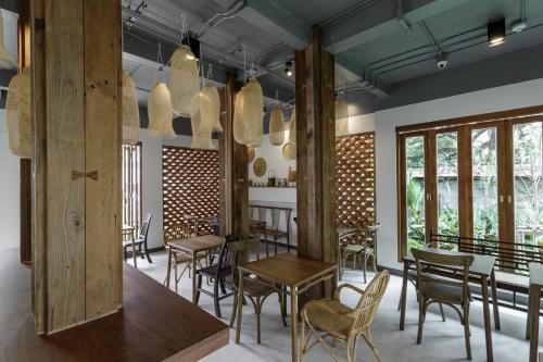 a dining room with tables and chairs and windows at The Locals Chiang Mai in Chiang Mai