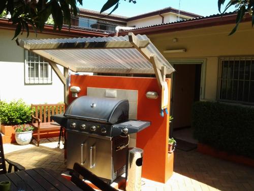 a barbecue grill with an awning on a patio at Randwick City Lodge 2 in Sydney