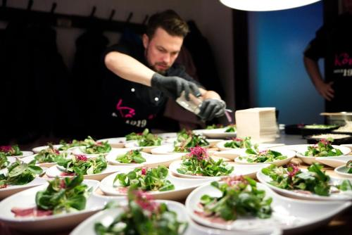 a man is preparing plates of food on a table at Köhlz Fewo im EG in Bornheim