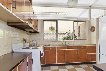 Relax at Tranquil Rye short walk to beach & shops في راي: مطبخ كبير مع حوض وموقد