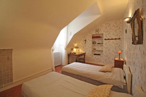 Cette chambre mansardée comprend 2 lits et une fenêtre. dans l'établissement Domaine de Bort, à Saint-Priest-Taurion