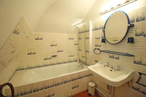 uma casa de banho com uma banheira, um lavatório e um espelho. em Domaine de Bort em Saint-Priest-Taurion