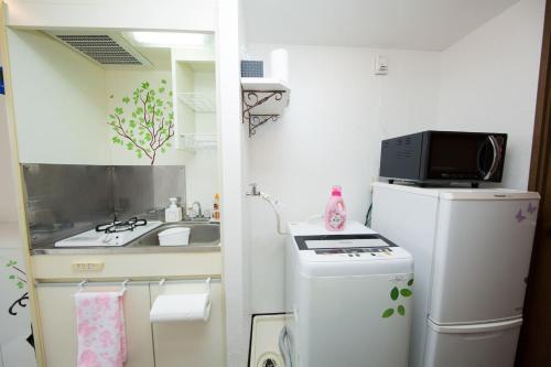 a small kitchen with a sink and a refrigerator at Cozy house 402 free wifi a rented electric bicycle in Kyoto