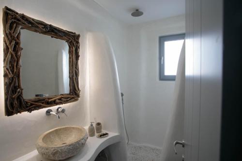 a bathroom with a sink and a mirror on the wall at Majestique of Naxos luxury suites in Naxos Chora