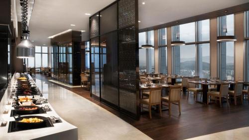 a dining room with a long table with plates of food at Lotte City Hotel Jeju Airport in Jeju