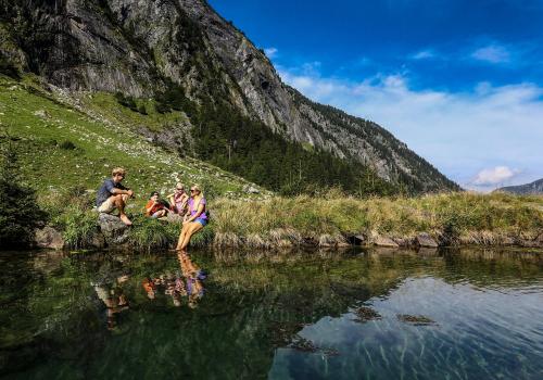 a group of people sitting on the side of a river at edelweiss lounge restaurant hotel pizza cafe billard gasthof in Mayrhofen