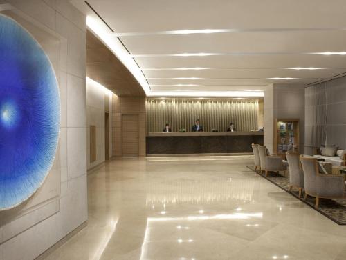 a lobby with a large blue eye on the wall at Lotte City Hotel Jeju Airport in Jeju